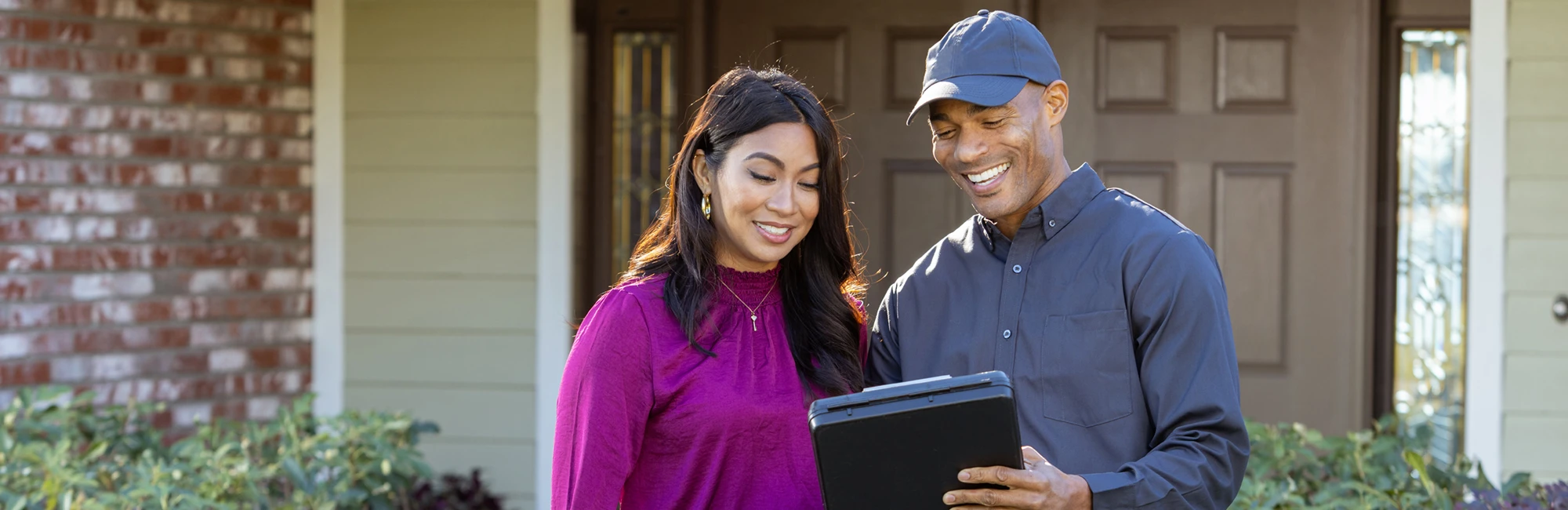 Exterminator speaking with home owner in front of house | All Good Pest Solutions serving Knoxville, TN